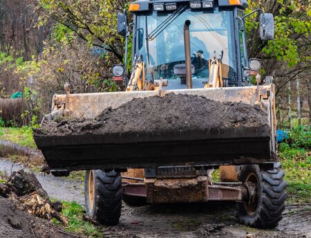 Fragment of the excavator. Repair work on the street of a residential quarter.の写真素材