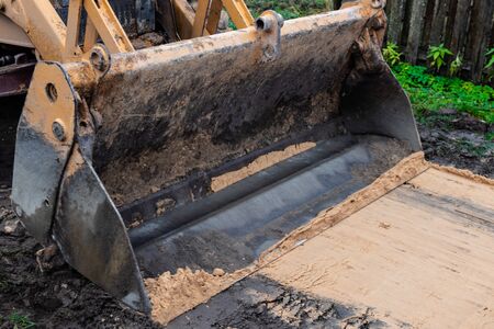 Fragment of the excavator. Repair work on the street of a residential quarter.の写真素材