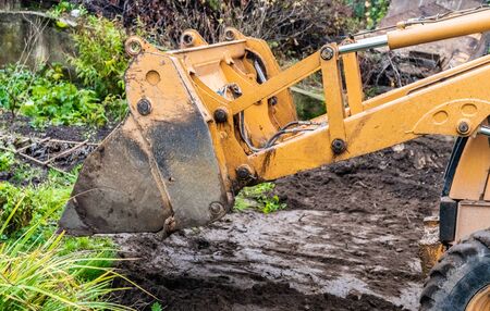 Fragment of the excavator. Repair work on the street of a residential quarter.の写真素材