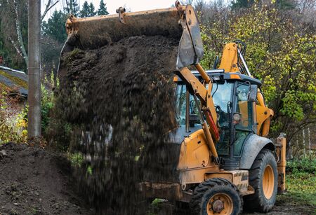 Fragment of the excavator. Repair work on the street of a residential quarter.の写真素材