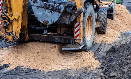 Fragment of the excavator. Repair work on the street of a residential quarter.の写真素材