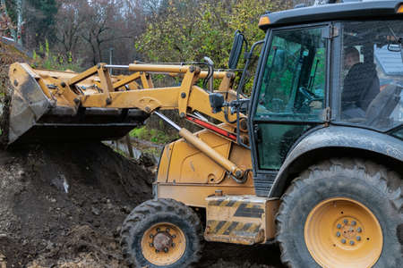 Fragment of the excavator. Repair work on the street of a residential quarter.のeditorial素材