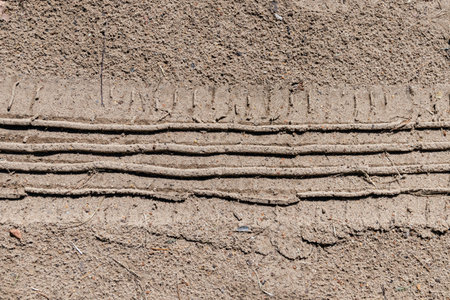 Drawing of a car wheel on the sand. Close-up.