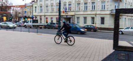 12-19-2019. Vilnius, Lithuania. A man on a bicycle rides down a street in the central part of the old city.のeditorial素材