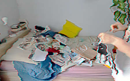 A person with a magazine in his hands by the bed. Mess. Glitch effect.の写真素材