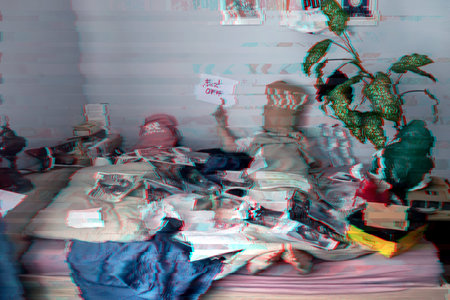 Man with a paper bag on his head in bed. A mess. Glitch effect.