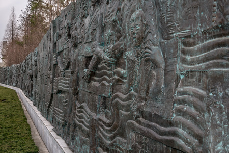 A huge stone wall with a relief pattern of battle. Relief sculpture in the Memorial Hall of the victims in the Nanking Massacreの写真素材