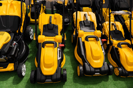 yellow lawn mowers stand in a row. High quality photo