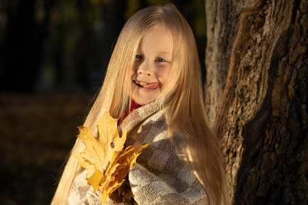little blonde girl in a plaid whip in the parkの写真素材