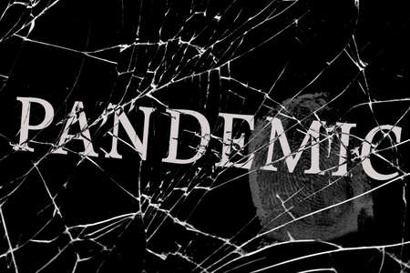 gloomy broken glass with cracks with the inscription pandemicの写真素材