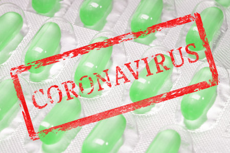 stamp with the inscription coronavirus on the background of a blister with pillsの写真素材