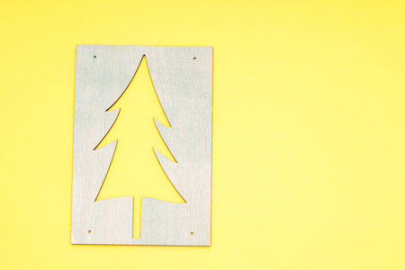 wooden pattern of a Christmas tree on a yellow