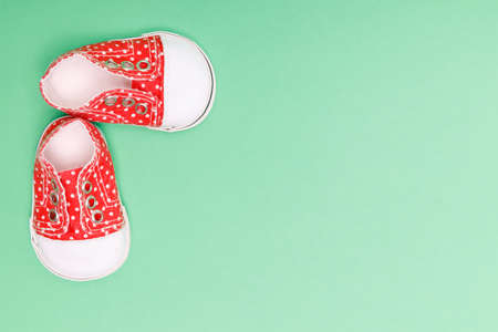 baby shoes with white polka dots on a green backgroundの写真素材