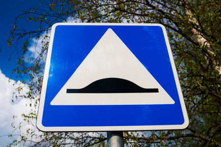 road sign speed bump. blue square with white triangle and black obstacleの写真素材