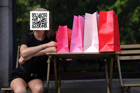 girl with qr code on her face with shopping bags. Constraint conceptの写真素材
