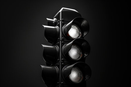 A detailed view of a traffic light against a black background. Suitable for illustrating transportation, urban infrastructure, and road safety concepts.の素材