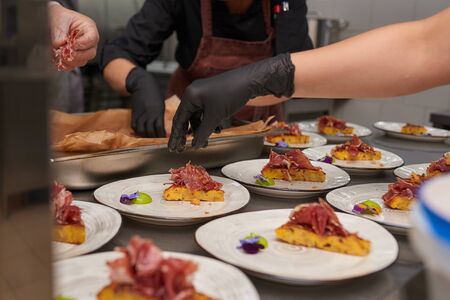 Laying a lot of bruschetta on plates. Cooking on a plate in a restaurant.の写真素材