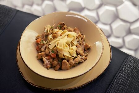 Appetizing Italian pasta close-up with beef on a plateの写真素材