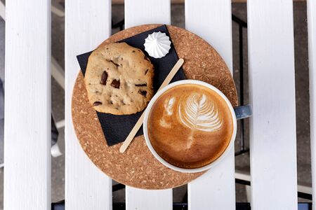 Coffee in a turquoise mug and cookies on a white table the top viewの写真素材