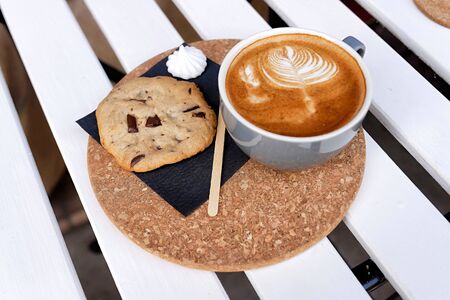 Coffee in a turquoise mug and cookies on a white table the top viewの写真素材