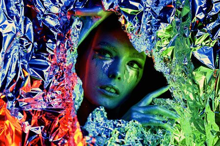 Color high fashion woman neon lights. Rainbow make-up, portrait of a girl isolated on a colored background. Colorful color scheme close-upの写真素材