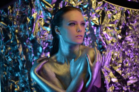 Portrait of beautiful young cosmic woman, girl, model, star, celebrity. Blue background. Bright creative makeup, perfect body, expressive, pose, colors.Elf style.Hair. Fur. High fashion. Neon.の写真素材