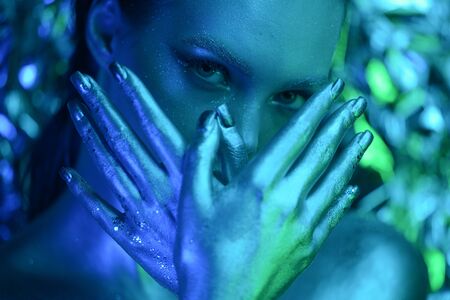 Beauty, cosmetics and makeup. Magic eyes look with bright creative make up. Macro shot of beautiful woman's face with perfect art makeup with glitter. Closeup. Body artの写真素材