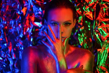 Fashion model woman in neon light, portrait of beautiful model with fluorescent make-up, Art design of female disco dancers posing in UV, colorful make up. Isolated on black backgroundの写真素材