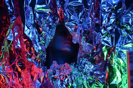 Portrait of a beautiful girl closeup. Face painted blue paint. The effect of the collapse. flying powder particles. The concept of spaceの写真素材