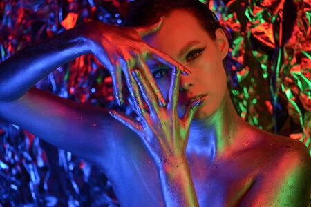 portrait of a woman with neon lights and bright makeupの写真素材