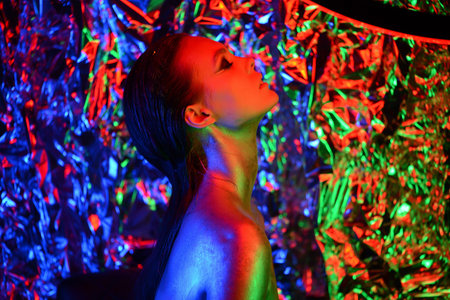 High Fashion Model with Trendy Wavy Hairstyle in pink glowing neon light. Glamour Sexy Girl in...