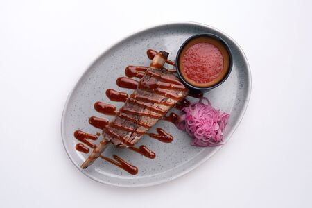 Modern style barbecue dry aged sliced roast beef with fried onion rings and mashed potatoes as closeup on a plateの写真素材