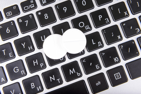 pills on a laptop keyboardの写真素材