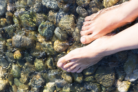 feet in the crystal clear sea waterの写真素材