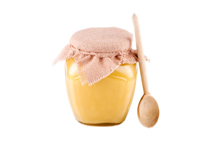jar of honey and spoon on a white backgroundの写真素材