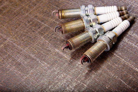 composition of four spark plugs on a metal background.