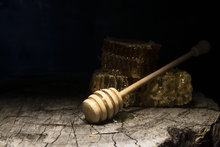 honeycombs and stick to honey on wooden backgroundの写真素材