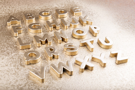 Gold English alphabet on a gold backgroundの写真素材