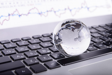 business concept of a glass globe on a laptop keyboardの写真素材