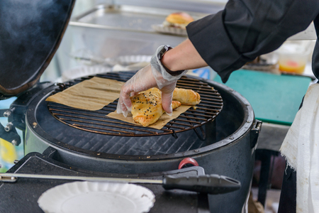 Chef making beef burgers outdoor on open kitchen international food festival event.の写真素材