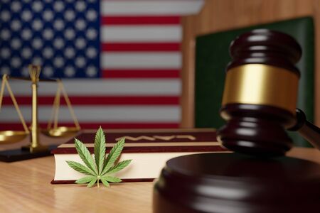 Legalization of cannabis in the United States, a cannabis leaf lies on the judge's Desk against the background of the us flagの写真素材