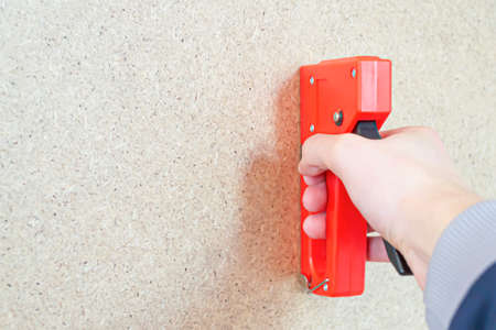 A worker installs plywood using a close-up stapler.Background for designers.の写真素材