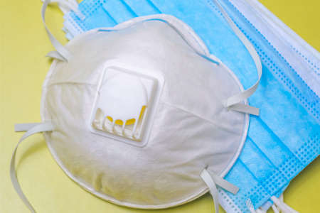 A mask with a protective filter and many medical masks on  yellowの写真素材