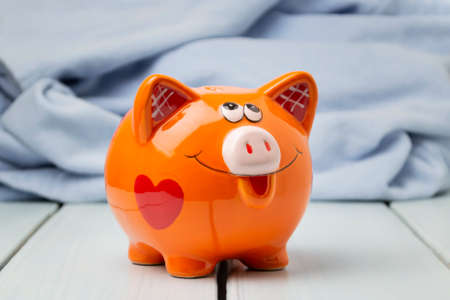 Piggy bank in the shape of a pig on a wooden background.の写真素材