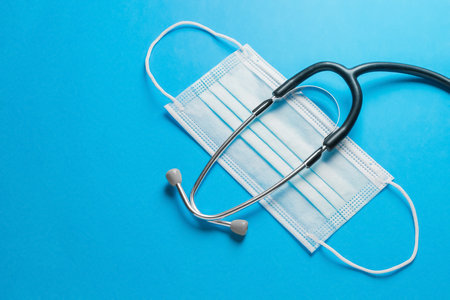 Medical device stethoscope and protective medical mask on a blue background.Close up.Copy space.の写真素材