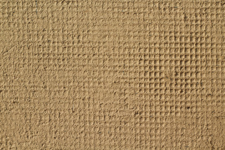 Plaster on the grid, renovating outdoor walls, brown background