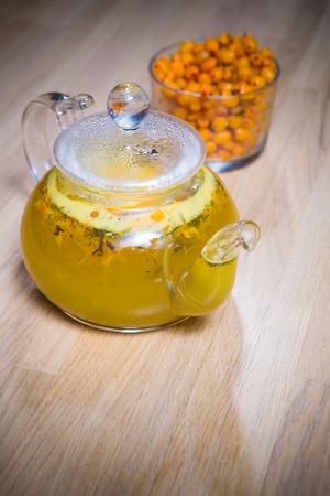 sea-buckthorn tea in a glass teapotの写真素材