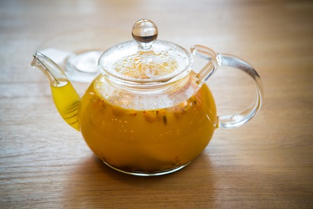 sea-buckthorn tea in a glass teapotの写真素材