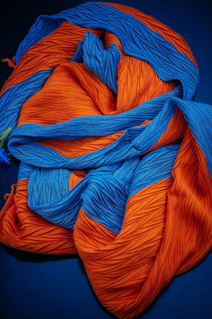 fragment of a blue-orange scarf texture on a blue backgroundの写真素材