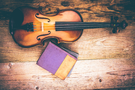 Ancient violin on a table of rough unplaned boardsの写真素材